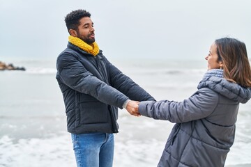 Canvas Print - Man and woman couple smiling confident dancing at seaside