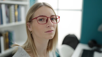 Sticker - Young blonde woman sitting with serious expression at library university