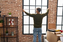 Young arab man measuring window at new home