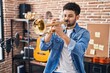 © Krakenimages.com - Young arab man musician playing trumpet at music studio
