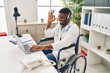 Poster - African american doctor man working on online appointment sitting on wheelchair doing ok sign with fingers, smiling friendly gesturing excellent symbol