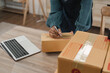 © Natee Meepian - Entrepreneur, small business, SME, freelance woman working from home with lots of boxes on the side. Use smartphones and laptops for commercial monitoring. online marketing packaging box online sale
