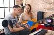 © Krakenimages.com - Man and woman musicians having classic guitar lesson using touchpad at music studio