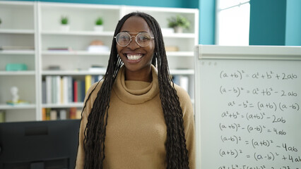 Wall Mural - African woman smiling confident by maths magnetic board at library university