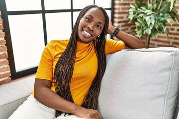 Sticker - African american woman smiling confident sitting on sofa at home