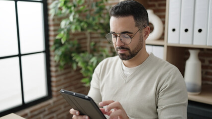 Sticker - Young hispanic man business worker using touchpad working at office