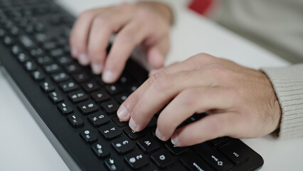 Young hispanic man using computer keyboard at office