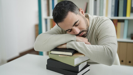 Sticker - Young hispanic man student sleeping with head on books at library university