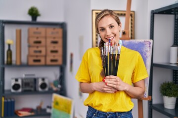 Sticker - Young blonde woman artist smiling confident holding briefcase at art studio