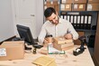 © Krakenimages.com - Young hispanic man e-commerce business worker drinking coffee write on package at office