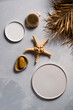 Photo of a cosmetic healthcare beauty product like handmade soap and wooden body brush in with creative set-design dry leaves, sea star and porcelain plates on a concrete background flat lay  