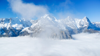 Poster - Natural background. Mountains and clouds in the valley. Natural landscape high in the mountains. Mountain range through the clouds.