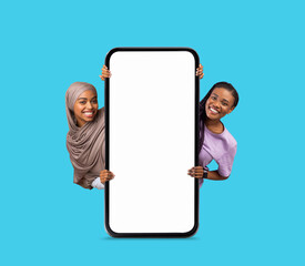 Poster - Online Advertisement. Two Happy Females Holding Big Blank Smartphone With White Screen
