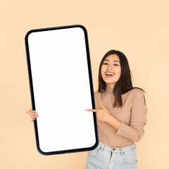 Poster - Mobile Ad. Smiling Asian Woman Holding And Pointing At Big Blank Smartphone