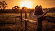 Illustration of a cowboy hat on a fence - Scene with a beautiful sunset