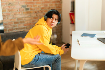 Wall Mural - Japanese Teen Guy Using Smartphone Having Quarrel With Mother Indoors