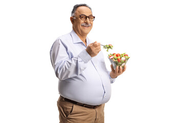 Canvas Print - Mature man standing and eating a salad