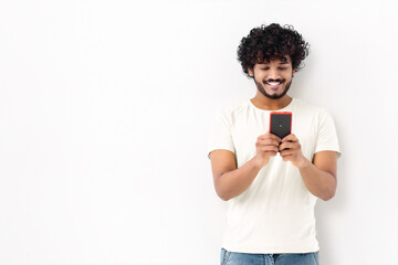 Wall Mural - Smiling Asian student man in a white t-shirt hold in hands use mobile cell phone, sends a message, chatting online standing isolated on white background