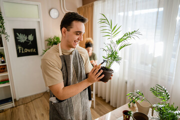 Wall Mural - Couple caucasian man and woman wife and husband planting flowers together taking care of home plants real people domestic life family gardening concept copy space