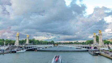 Wall Mural - Bridge of Alexandre III spanning the river Seine timelapse hyperlapse. Decorated with ornate Art Nouveau lamps and sculptures. Aerial view from Invalides bridge. Paris. France. Cloudy sky at sunset