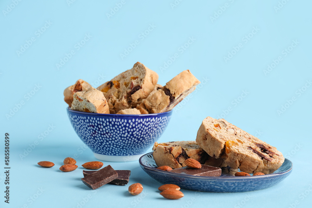 Delicious biscotti cookies, almond nuts and chocolate on blue background