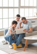 © Pixel-Shot - Happy little boy with his dad and grandfather using laptop at home