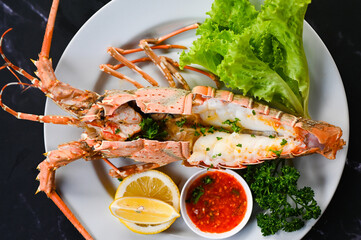 Wall Mural - spiny lobster food on plate, fresh lobster or rock lobster seafood with herb and spices lemon coriander parsley lettuce salad, lobster for cooking food and seafood sauce