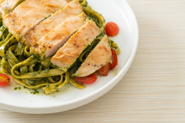 Wall Mural - fettuccine spaghetti pasta in pesto sauce with grilled chicken