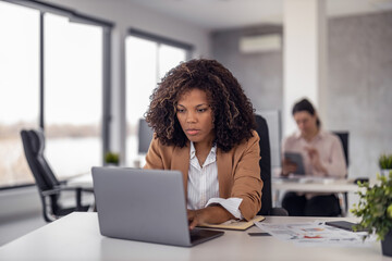 Shot of young entrepreneur woman working with laptop in the office