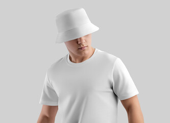 Wall Mural - Mockup of a white panama for protection from the sun, a hat on a young man in a t-shirt, clothing for design, branding, advertising.
