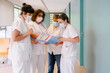 © Westend61 - Doctor explaining medical report to colleagues standing at hospital corridor