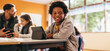 © Jacob Lund - Boy smiling at the camera while sitting with a digital tablet in a classroom