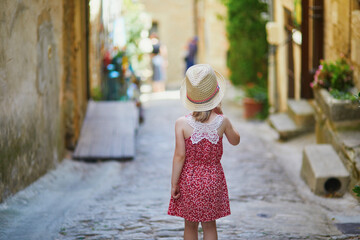 Wall Mural - Adorable preschooler girl walking on a street of Medieval village of Gordes in Southern France