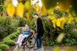 © Astrakan Images - Disabled woman in wheelchair with assistant in garden