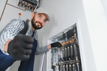 Wall Mural - Young engineer adjusting autonomous heating