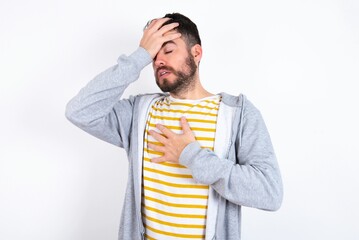 Young caucasian mán wearing trendy clothes over white background Touching forehead for illness and fever, flu and cold, virus sick.