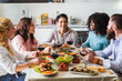 © Alessandro Grandini - Group of multiethnic friends sitting at the table during lunch