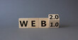 © Natallia - WEB 2 or 1 symbol. Turned wooden cubes with words WEB 1.0 or WEB 2.0. Beautiful grey background. Business and WEB concept. Copy space