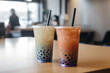 Pair of bubble tea cups with straws on a counter, blurred background