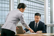 © imtmphoto - asian business manager reviewing report with subordinate in office
