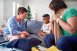 © Caia Image - Lesbian couple scolding unhappy son on living room sofa