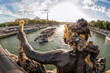 The Pont Alexandre III (bridge) with sculptures against tourist boat on Seine and Eiffel Tower in Paris, France