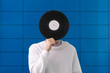 © Mihail - male music lover holding a black vinyl record and cover his face