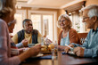 © Drazen - Happy senior woman talks to her friends during lunch in residential care home.