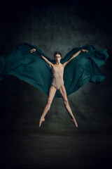 Wall Mural - Portrait of beautiful dancer flying with silk fabric over dark green background