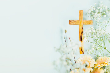 wooden cross with spring flowers on blue background with copy space. religion background. religious 