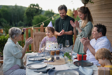 Wall Mural - Multi generation family celebrating birthday and have garden party outside in the backyard on patio.