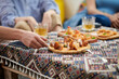 © DragonImages - Closeup image of young people eating delicious snacks when hanging out together in pub