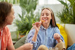 © DragonImages - Smiling young woman eating tasty snacks when ejoying romantic date with boyfriend