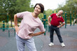 © caftor - Aged man and woman practicing gymnastics in open-air sports area